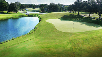 view of golf course hole with pond trap on the left